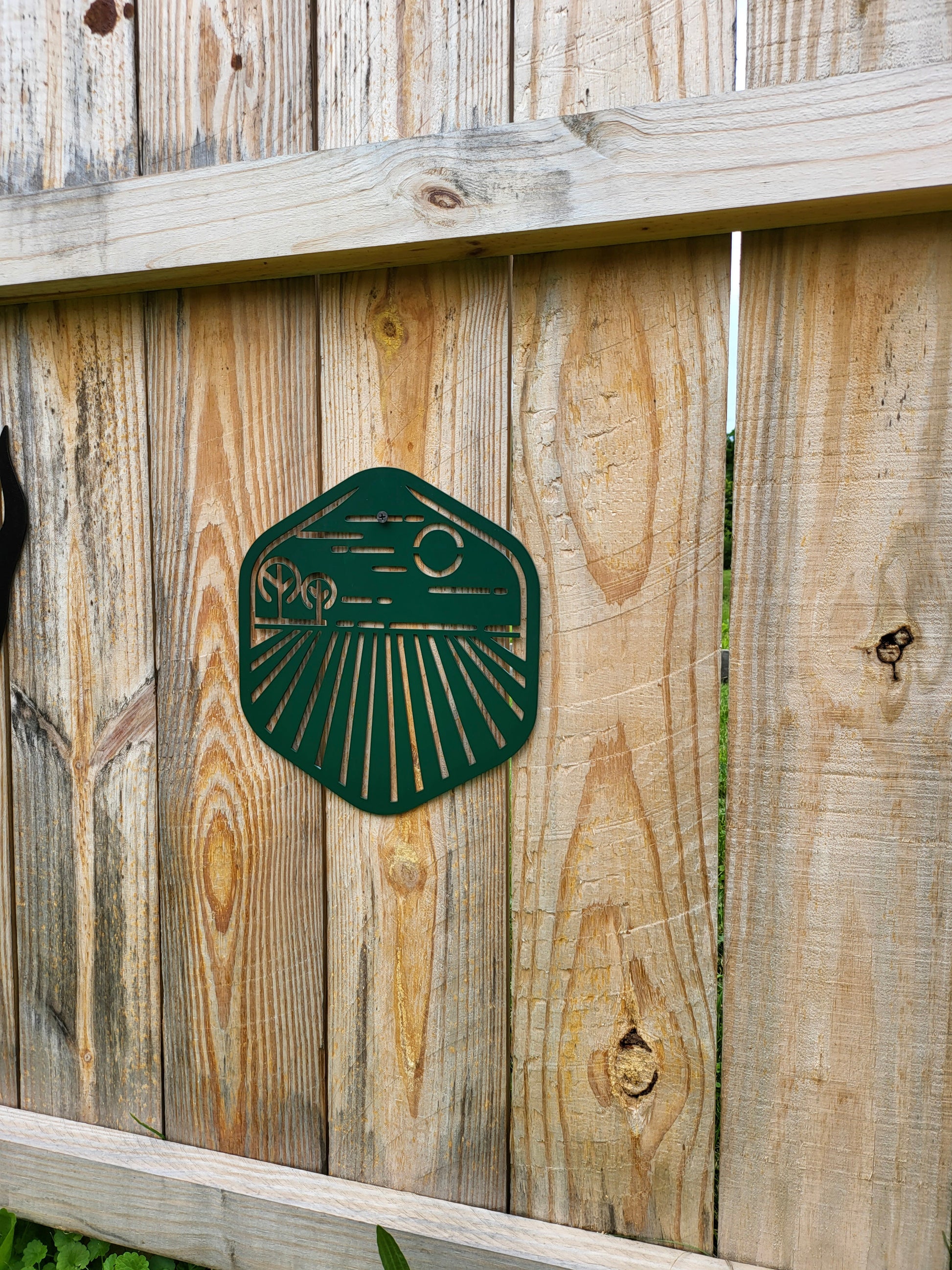 green laser art farm scene on a wood fence